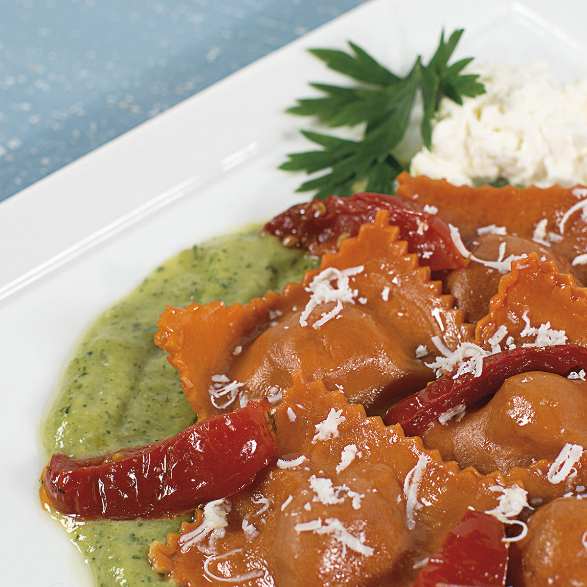 Ravioli rosa con burrata su crema di zucchine con filetti di pomodoro confit